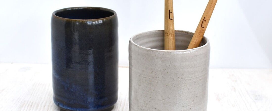 Two bamboo toothbrushes in a grey Clod & Pebble ceramic toothbrush holder