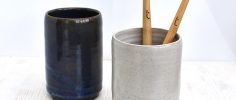 Two bamboo toothbrushes in a grey Clod & Pebble ceramic toothbrush holder