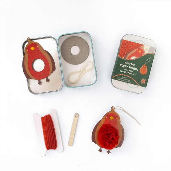 Cotton Twist Rosy Robin pom pom kit: open and closed metal tins, wooden base, red yarn, and finished ornament.